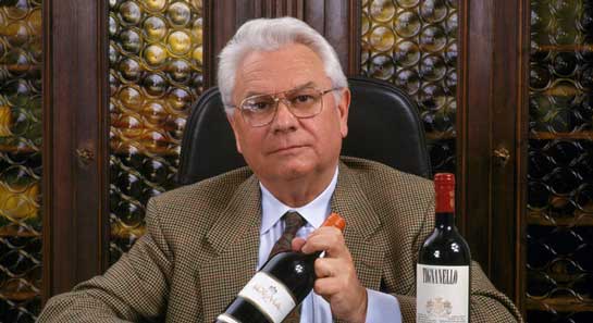 Giacomo Tachis showing bottle of wine